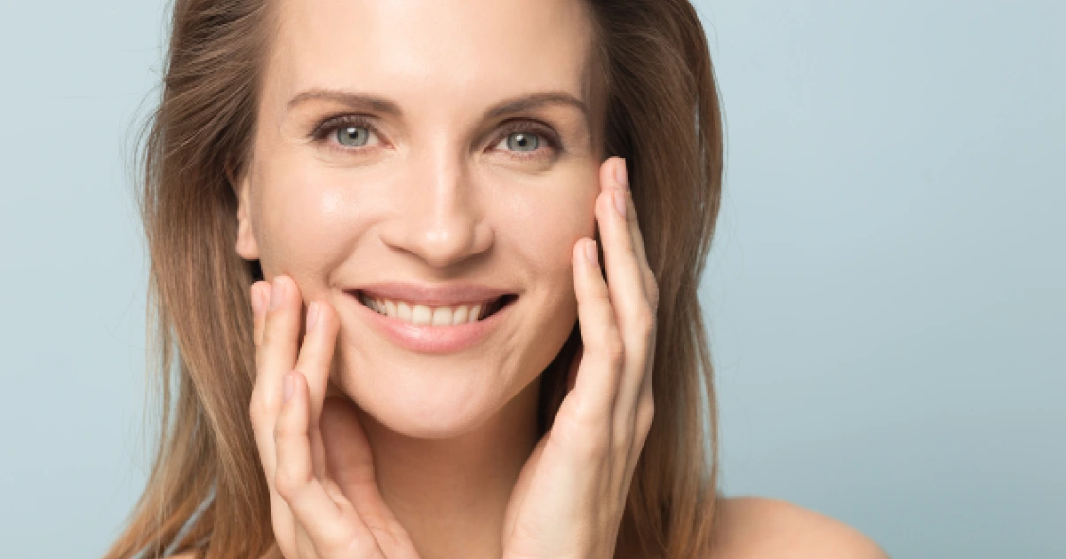 Smiling woman touching her smooth skin after PRF gel treatment in Stoneham, MA